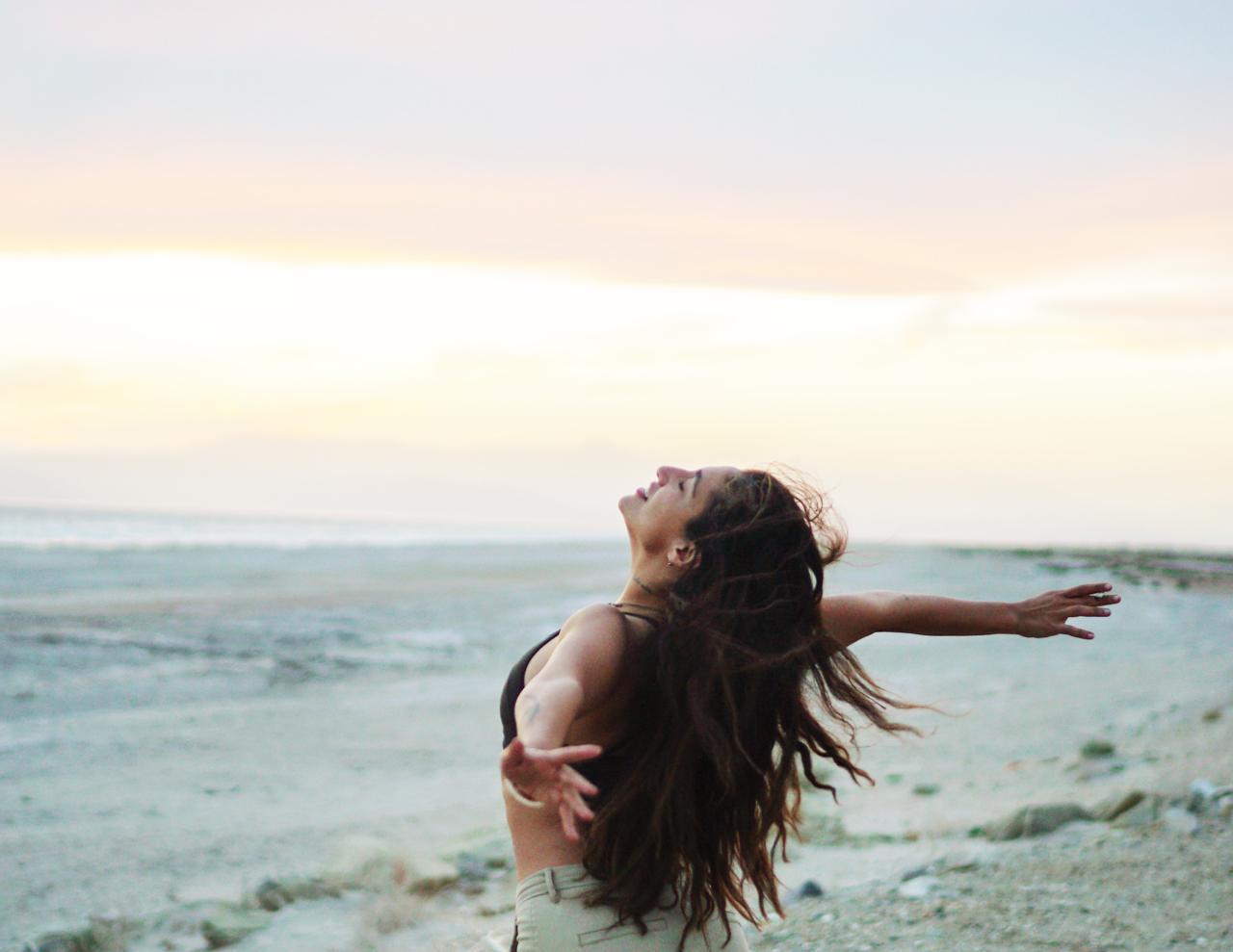 Woman at beach, arms open in freedom